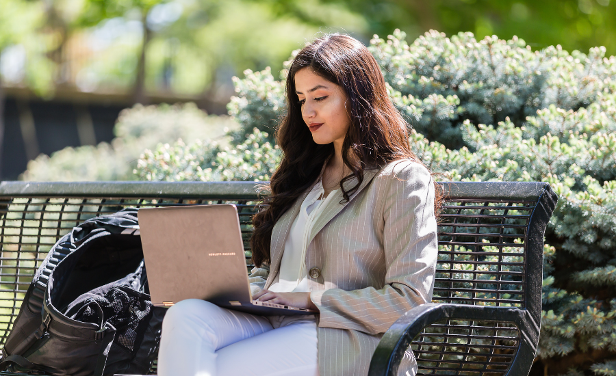 Woman on park bench taking an online degree assessment to see if online learning is right for her.